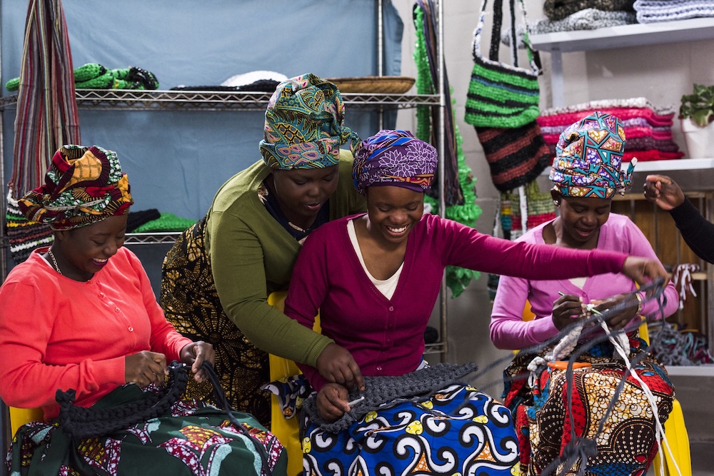 African women together making purses and bags