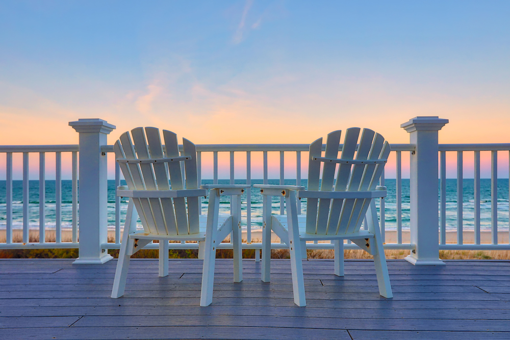 chairs on a balcony at sunset at the beach