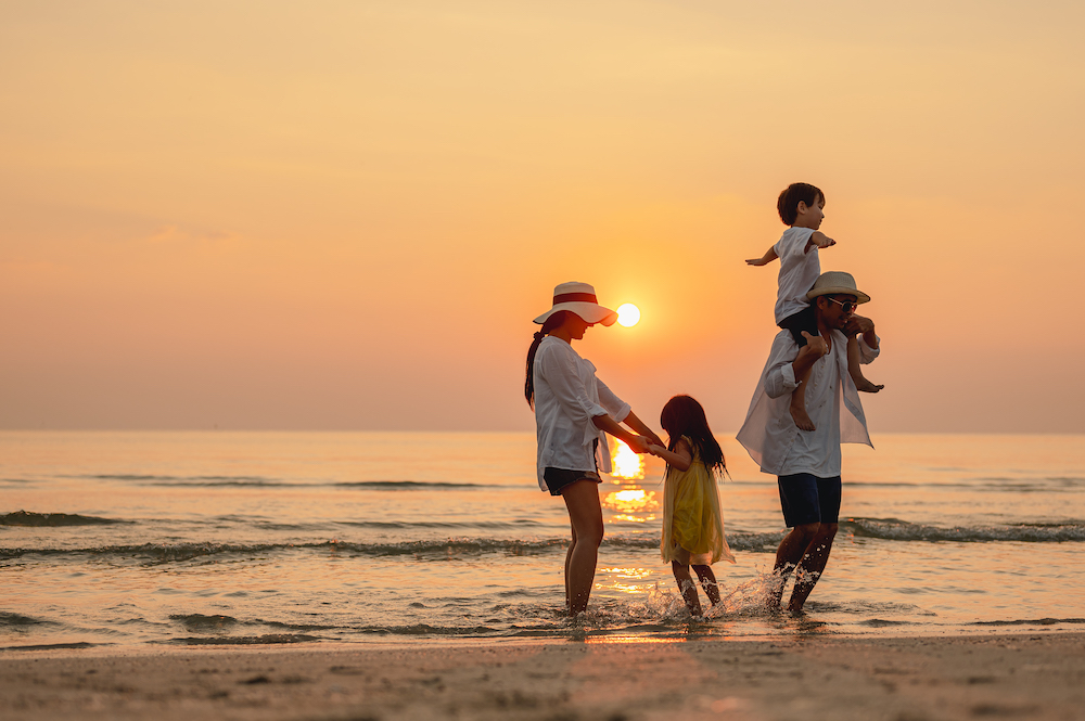 family on beach at sunset